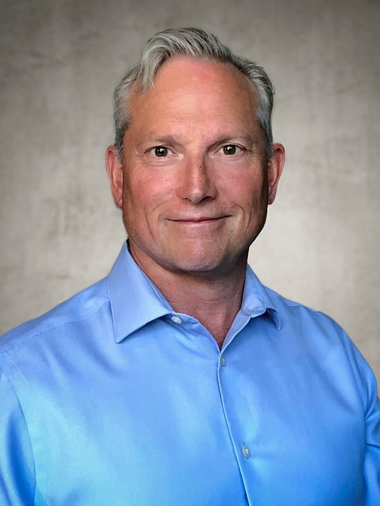 David Main in a dress shirt, smiling